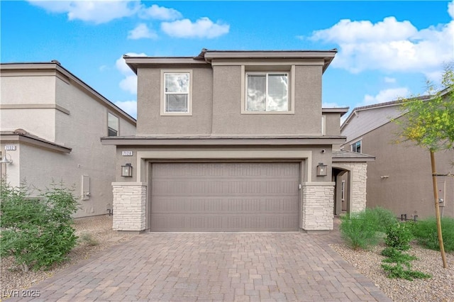 traditional-style home featuring an attached garage, stucco siding, decorative driveway, and stone siding