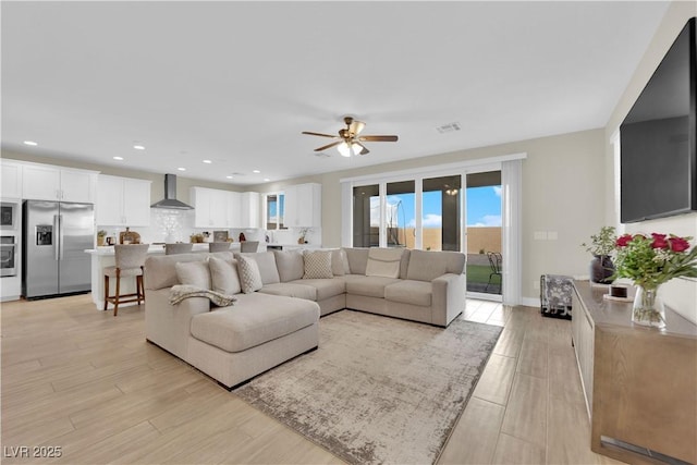 living area with visible vents, light wood-style flooring, ceiling fan, and recessed lighting