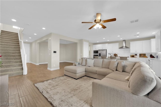 living area with recessed lighting, ceiling fan, visible vents, stairs, and light wood-style floors