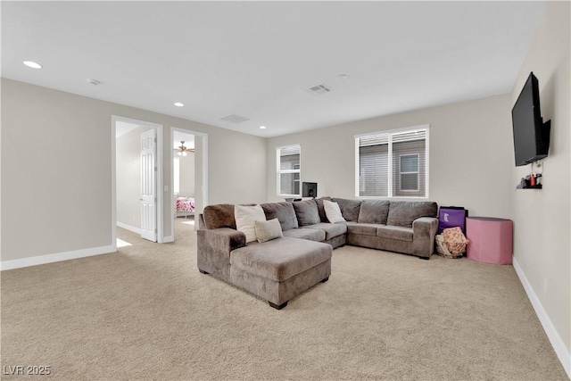 living area with baseboards, recessed lighting, visible vents, and light colored carpet