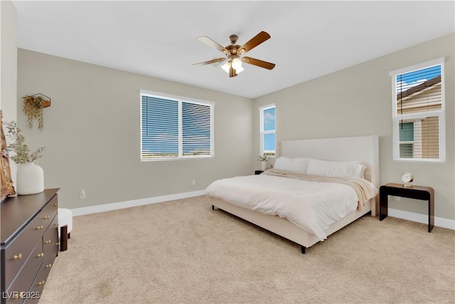 bedroom featuring light carpet, baseboards, and multiple windows