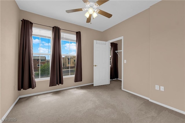 unfurnished room featuring carpet, baseboards, and a ceiling fan