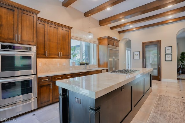 9500 Balatta Canyon Ct, Las Vegas, NV 89144 - kitchen featuring stainless steel appliances, arched walkways, a warming drawer, beam ceiling, and a sink