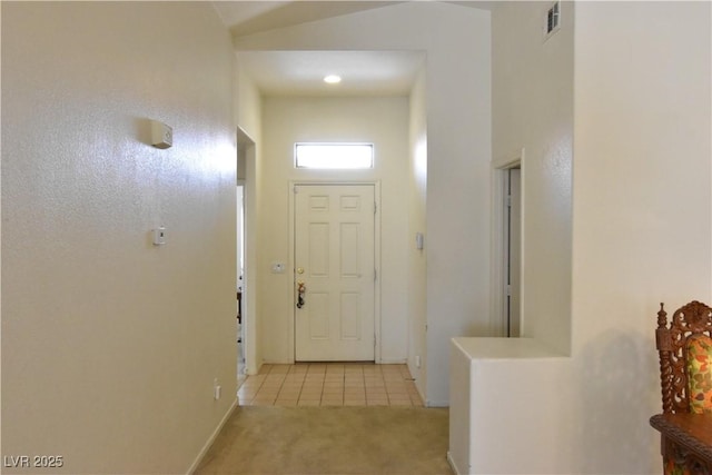 doorway featuring carpet flooring, baseboards, visible vents, and tile patterned floors