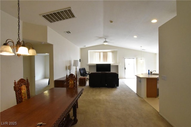 interior space with vaulted ceiling, a chandelier, light carpet, and visible vents