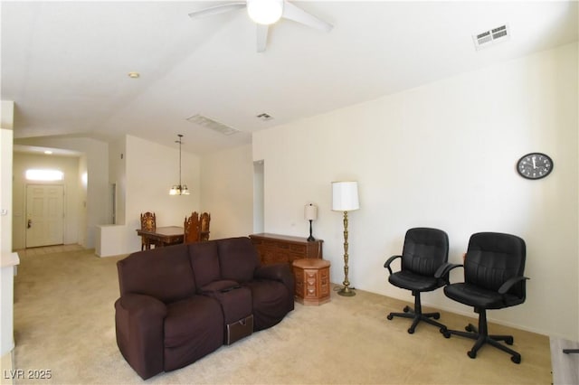 carpeted living area with visible vents, lofted ceiling, and a ceiling fan