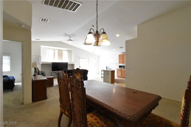 dining space with lofted ceiling, light carpet, ceiling fan with notable chandelier, and visible vents