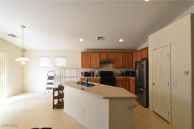 kitchen featuring freestanding refrigerator, visible vents, stainless steel microwave, a sink, and black gas range