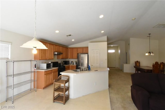 kitchen featuring under cabinet range hood, a sink, open floor plan, light countertops, and appliances with stainless steel finishes