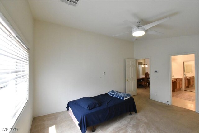 bedroom with ceiling fan, connected bathroom, visible vents, and carpet floors