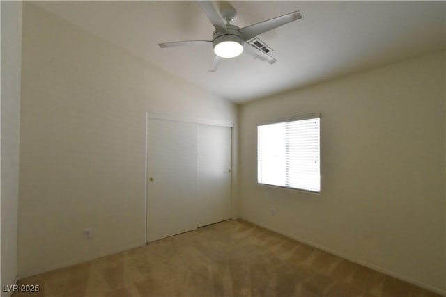 spare room featuring lofted ceiling, a ceiling fan, and carpet floors