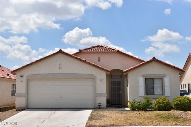 mediterranean / spanish home with an attached garage, a tiled roof, and stucco siding