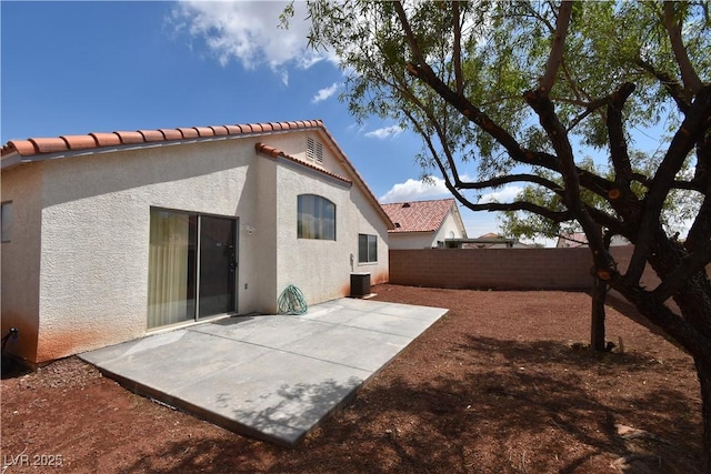 back of house with central air condition unit, a tile roof, a patio, stucco siding, and a fenced backyard