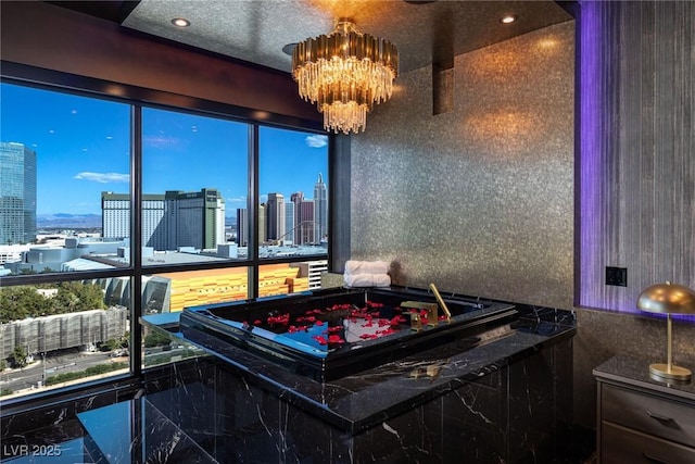 rec room featuring a city view, an inviting chandelier, and marble finish floor