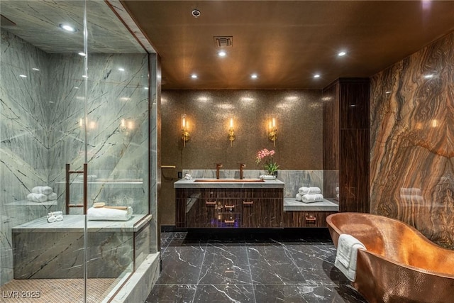 full bathroom with recessed lighting, marble finish floor, vanity, a freestanding bath, and a marble finish shower