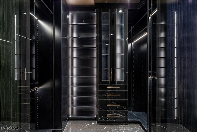 walk in closet with marble finish floor