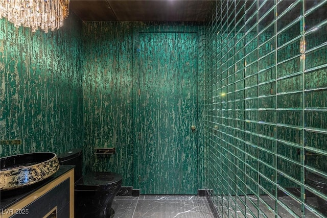 bathroom featuring toilet, a notable chandelier, and vanity
