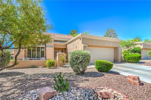 view of front of house with fence, an attached garage, driveway, stucco siding, and a tiled roof