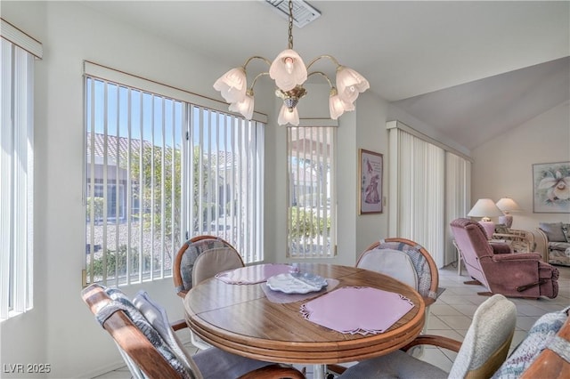 tiled dining area with lofted ceiling, an inviting chandelier, and plenty of natural light