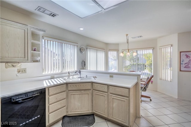 kitchen featuring light brown cabinets, dishwasher, visible vents, a sink, and a peninsula