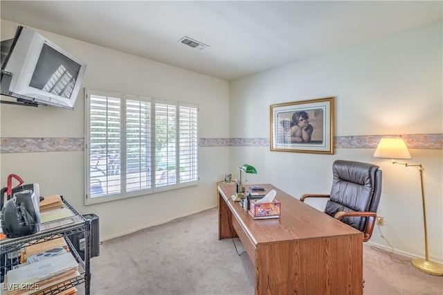 home office with visible vents, baseboards, and light carpet