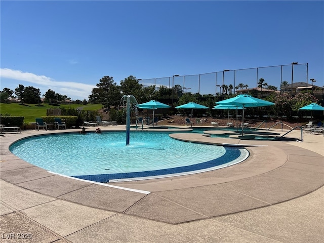 community pool with a patio and fence