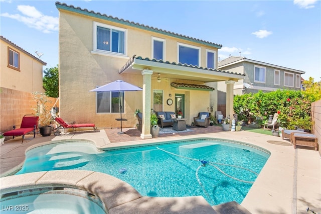 rear view of house with fence, a patio area, stucco siding, an outdoor living space, and a fenced in pool
