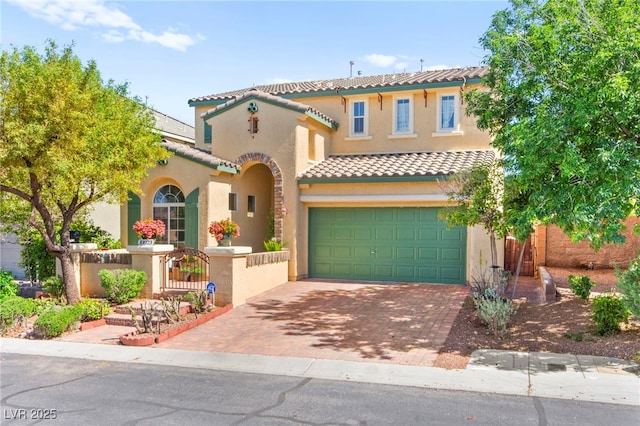 mediterranean / spanish-style home featuring a tile roof, stucco siding, decorative driveway, and a fenced front yard