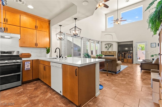 kitchen featuring a sink, visible vents, dishwasher, under cabinet range hood, and double oven range
