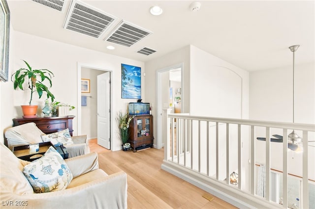 sitting room with ceiling fan, recessed lighting, visible vents, and light wood-style floors
