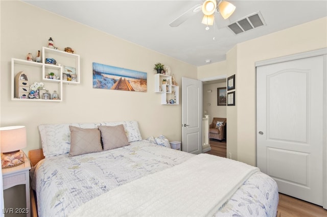 bedroom featuring a closet, visible vents, wood finished floors, and ceiling fan