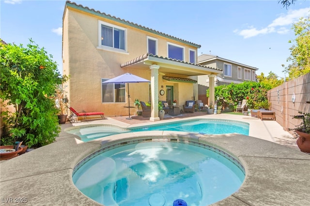 back of house featuring a fenced backyard, a patio, stucco siding, and a tiled roof