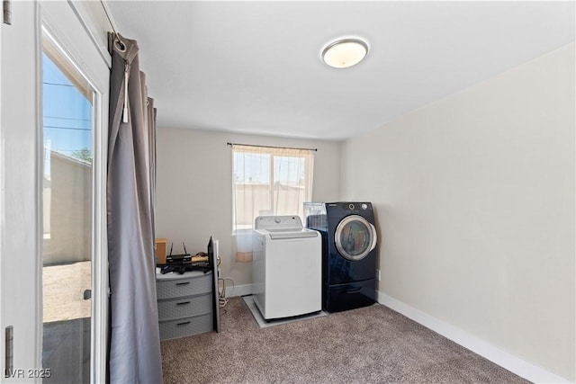clothes washing area with baseboards, laundry area, carpet floors, and washer and clothes dryer
