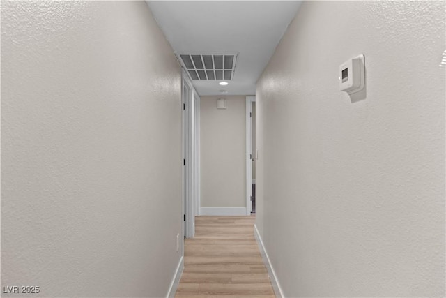 corridor featuring light wood finished floors, baseboards, visible vents, and recessed lighting