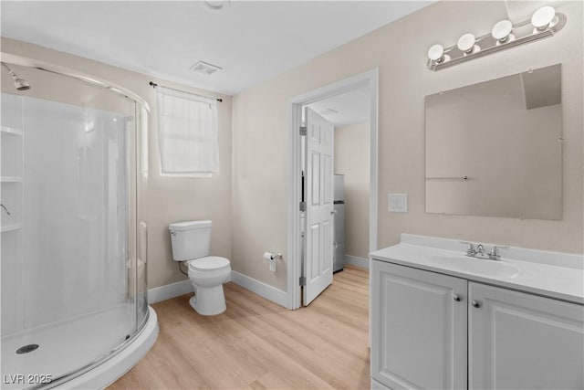 bathroom with a stall shower, vanity, visible vents, and wood finished floors