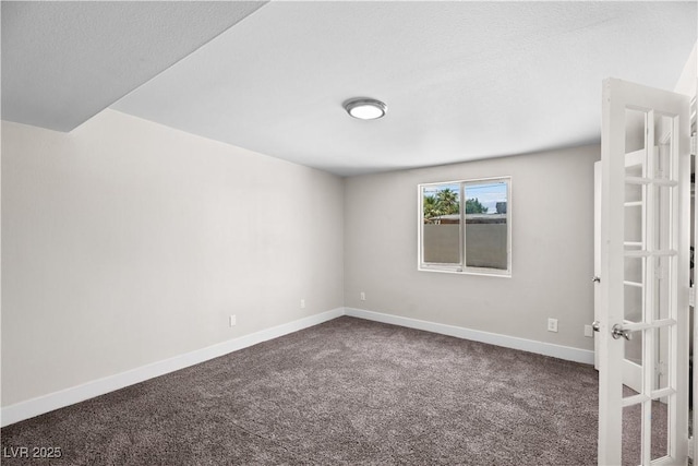 empty room with baseboards, french doors, and dark colored carpet
