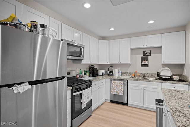 kitchen featuring a sink, stainless steel appliances, and white cabinets