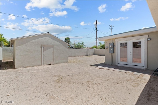 view of yard with an outdoor structure, french doors, and a fenced backyard