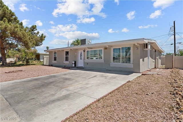 ranch-style house featuring driveway and fence