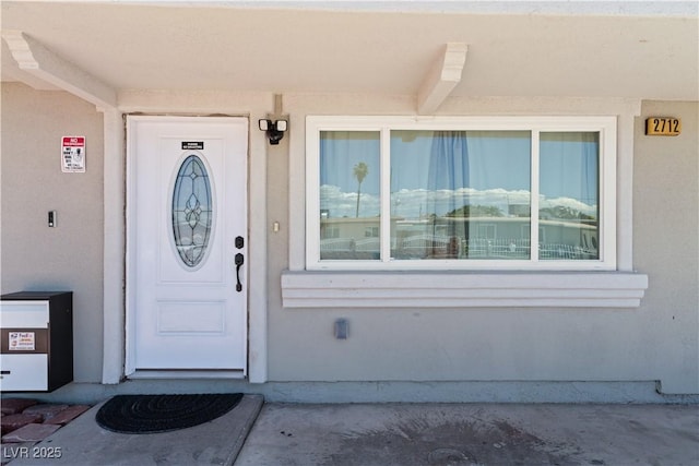 view of exterior entry featuring stucco siding