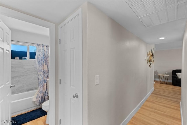 corridor featuring baseboards, light wood-style flooring, and visible vents