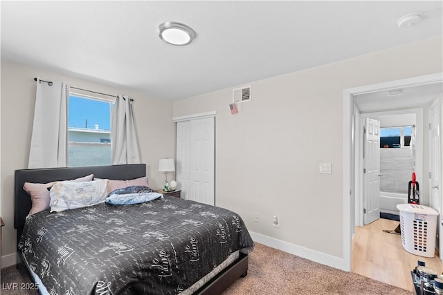 bedroom with baseboards, carpet flooring, a closet, and visible vents
