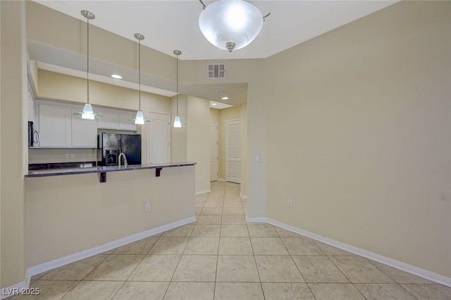 50 E Serene Ave Unit 420, Las Vegas, NV 89123 - kitchen featuring black fridge with ice dispenser, a kitchen breakfast bar, white cabinetry, dark countertops, and a peninsula