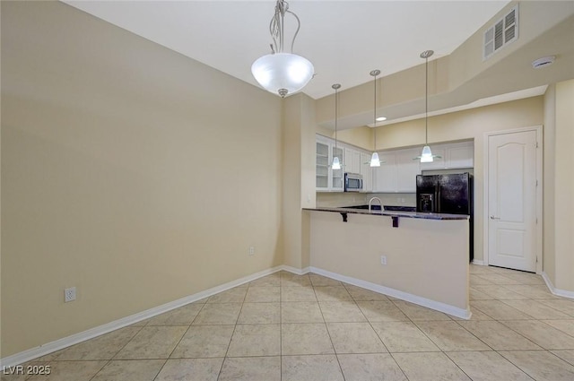 50 E Serene Ave Unit 420, Las Vegas, NV 89123 - kitchen with stainless steel microwave, black refrigerator with ice dispenser, a peninsula, white cabinetry, and light tile patterned floors