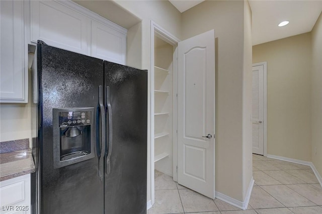 50 E Serene Ave Unit 420, Las Vegas, NV 89123 - kitchen featuring black fridge, white cabinets, and light tile patterned floors
