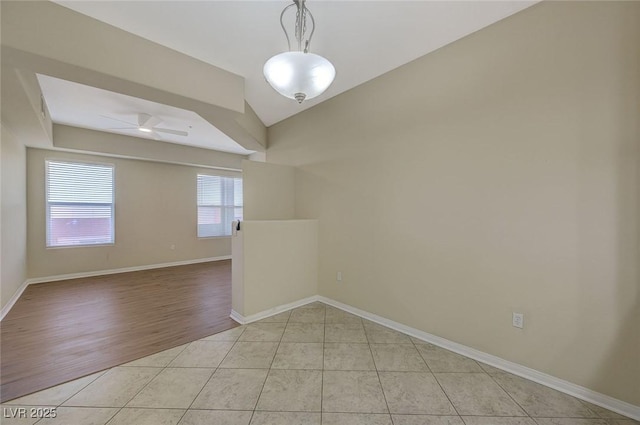 unfurnished room featuring ceiling fan, baseboards, and light tile patterned floors