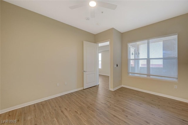 unfurnished room featuring a ceiling fan, wood finished floors, and baseboards