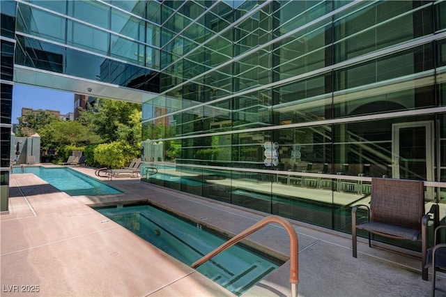 community pool with a patio and a community hot tub