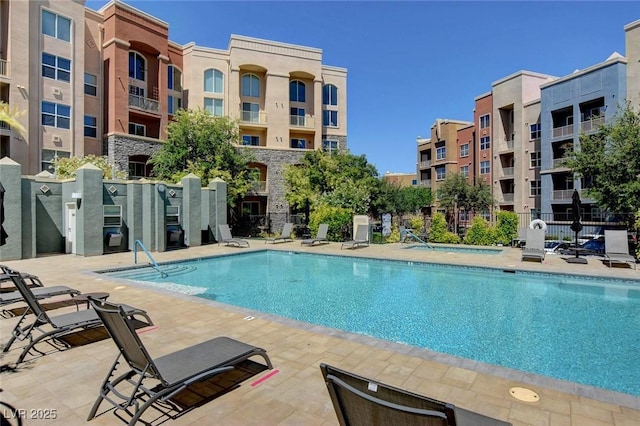 pool with a patio area and fence