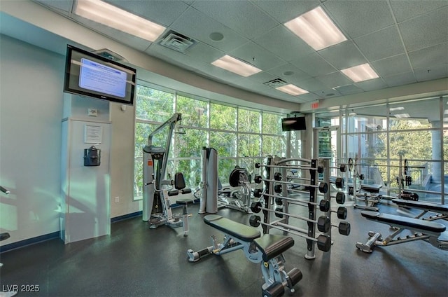 gym with a paneled ceiling and visible vents